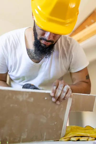 Parlak sarı kasklı bir inşaat işçisi, uzmanlığını ve güvenlik ve verimliliğini gösteren, tüm işlerin yüksek standartlara ulaşmasını sağlayan karmaşık bir projeye odaklanıyor.