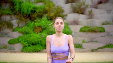 Güçlü, güzel bir kadın açık hava yoga ve çeşitli egzersizler yapıyor, atletik zarafetini ve sağlıklı bir yaşam tarzına bağlılığını gösteriyor, motive edici örneğini takip etmeleri için birçoklarına ilham veriyor.
