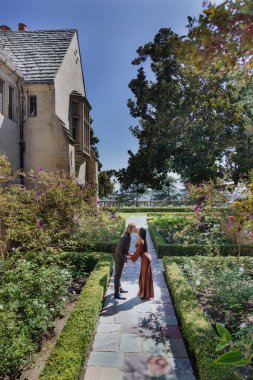 Büyüleyici bir nişan fotoşopu çarpıcı bir bahçede farklı bir çifti yakalıyor, aşklarını kutluyorlar ve kalpten bir evlilik teklifi, duyguları, sevinçleri ve gelecekleri için beklentileriyle dolu.