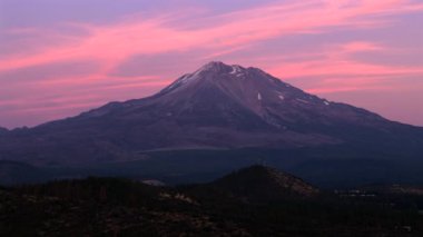 Kaliforniya, Shasta Dağı 'nın inanılmaz destansı bir görüntüsü, günbatımının büyüleyici renkleriyle ustaca yıkanmış, görkemli güzelliğini ve etrafını saran sakin atmosferini gözler önüne seriyor.
