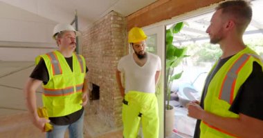 Yetenekli bir inşaat ekibi ev dekorasyonunda takım çalışması ve güvenliği ön plana çıkarıyor, parlak koruyucu giysiler giyiyor ve işbirliği, kaliteli işçilik ve detaylara dikkat ediyor