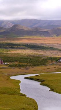 İzlanda 'nın engin platolarında nefes kesici hava manzarası yayılıyor. Uzak karlı dağlara uzanan çorak arazilerin geniş manzarası. Nehir İzlanda' nın katıksız güzelliğini simgeliyor.. 