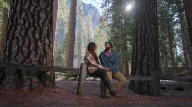 Yosemite Ulusal Parkı 'nda bir çift, doğal güzellik ve sükunetle mahrem bir anın tadını çıkarıyor. Arka plandaki görkemli El Capitan romantik kış ortamını güçlendiriyor.