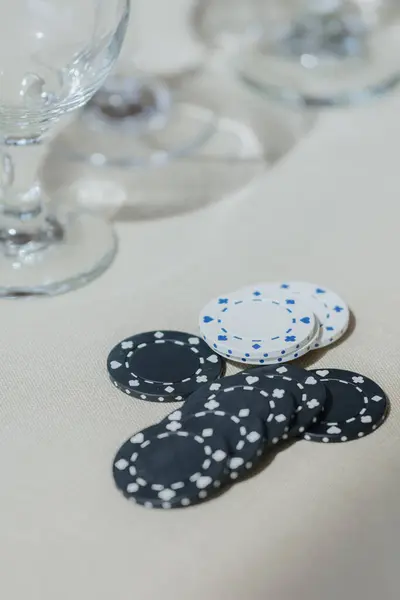 Büyüleyici bir yakın plan geleneksel siyah beyaz poker çiplerinin özünü yakalar. Güzelce dizilmiş bir masa üzerinde sersemletici bir şekilde arka planda görünür.