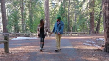 Güzel Afrikalı Amerikalı çift, Yosemite 'nin nefes kesen manzaralı patikalarında el ele romantik bir yürüyüş yapmayı seviyor. Etrafı dev ağaçlarla çevrili ve sonbahar harikalar diyarının büyüleyici güzellikleriyle dolu.