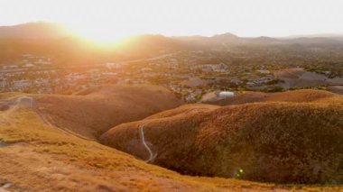 Hava fotoğrafında, güzel bir günbatımında sakin ve huzurlu bir Kaliforniya mahallesinde yerleşmiş ikonik Amerikan rüya evleri sergileniyor.