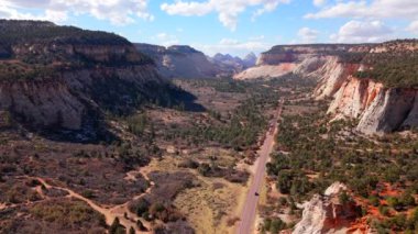 Zion Ulusal Parkı 'nın çarpıcı bir hava görüntüsü, etkileyici kırmızı kaya oluşumlarını ve bölgeyi çevreleyen resimli günbatımında nefes kesici manzaraları gözler önüne seriyor.