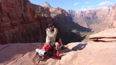 Afrika kökenli Amerikalı yürüyüşçülerin, Zion Ulusal Parkı 'nın yüksek ve görkemli kızıl kaya oluşumlarıyla çevrelenmiş manzarasıyla uzun bir yürüyüşten sonra içmesi bir dakika sürer.