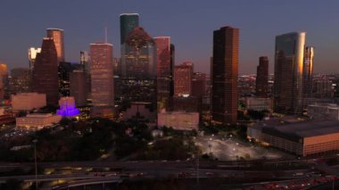 Houston, Teksas 'ın nefes kesen hava görüntüsü, çarpıcı bir günbatımı arka planına güzel bir şekilde karşı duran renkli ufuk çizgisini vurguluyor, araba otoyolu kavşağı ile pitoresk bir şehir manzarası yaratıyor. 