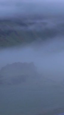 İzlanda 'nın yemyeşil tarlaları ve sis kaplı dağları gösteren güzel hava görüntüleri. Çarpıcı sinematik dron çekimleri bu nefes kesen bölgenin saf ve doğal güzelliğini yakalar..