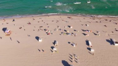 Sinematik hava görüntüleri Miami Beach, Florida 'nın güzelliğini gözler önüne seriyor. Tatilde ya da tatilde gezginlerle kıyı şeridi seriliyor. Kristal berrak Atlantik okyanuslarına karşı hareketli aktiviteler.
