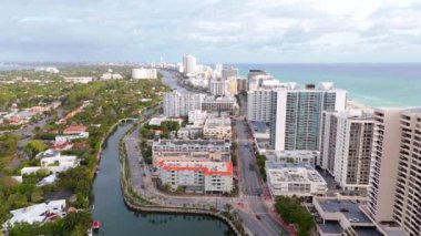 Bu çarpıcı hava manzarası, lüks evler, sudaki zarif tekneler ve parlak, güneşli bir gökyüzünün altında sallanan uzun palmiye ağaçlarının yer aldığı tropikal bir Miami Beach mahallesini gösteriyor.