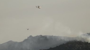 Acil müdahale ekipleri Los Angeles 'ta yangın söndürme suyu püskürtmek, evleri, toplulukları ve çevreyi ciddi hasarlardan korumak için uçak ve helikopter kullanıyorlar.