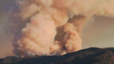 Şiddetli bir yangın Los Angeles yakınlarındaki dağları yutuyor ve yakındaki evleri tehdit ediyor. İtfaiyeciler, halkı ve halkı korumak için su damlaları için uçak ve helikopter kullanıyorlar.