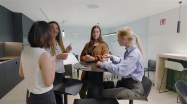 Modern ofiste üretkenliği artırmak için tasarlanmış, çeşitli ve hırslı iş kadınlarından oluşan canlı bir grup kahve molası sırasında anlamlı ve ilham verici bir konuşma ve işbirliği içerisindeler. 