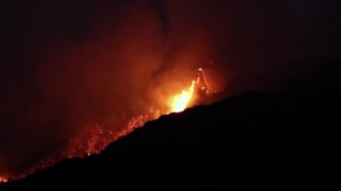 Büyük bir yangın Los Angeles yakınlarındaki dağları yutuyor, gece gökyüzünü alevler kaplıyor ve bu felaketin bölge üzerindeki yıkıcı etkisini gözler önüne seriyor.
