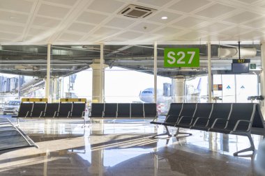 Modern havaalanı terminalinin geniş ve çağdaş tasarımı, şık oturma düzenleri ve yoğun pist ve işletimlerine bakan geniş bir bakış açısıyla S27 kapısını sunar.