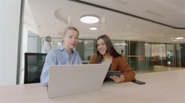 Modern bir ofis ortamında, iki profesyonel kadın iş birliği içinde çalışarak, çeşitliliğin hayati önemini ve başarıyı yönlendirmede takım çalışmasının önemini gözler önüne seriyor ve iş yerinde yenilikleri teşvik ediyor.