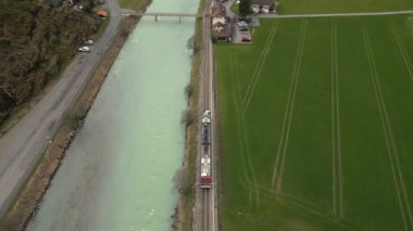 İsviçre 'deki Aare Gorge yakınlarında yukarıdan çarpıcı bir görüntü. Turkuaz bir nehrin kenarındaki yemyeşil çayırlarda tren yolculuğunun tadını çıkarın. Doğayı sevenler ve macera arayanlar için mükemmeldir.