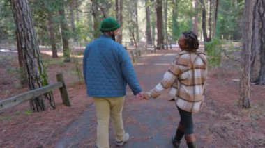 Mutlu bir çift, büyüleyici ve nefes kesici Yosemite Milli Parkı 'nda el ele dolaşır. Etrafı ağaçlarla çevrilidir ve sakin bir kış harikalar diyarıyla çevrilidir.