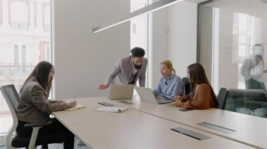 Çeşitli yetenekli ve yetenekli profesyonellerden oluşan bir grup, modern, iyi tasarlanmış bir ofis alanında aktif olarak iş birliği yapıyor, toplantı odasında takım çalışması, yaratıcılık ve yenilikçi fikirler sergiliyor.