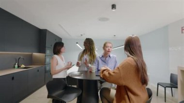 Modern bir ofiste, yetenekli profesyonellerden oluşan çeşitli bir ekip, yaratıcılığı, ileri görüşü ve üretkenliği artıran yenilikçi fikirler alışverişinde bulunuyor.