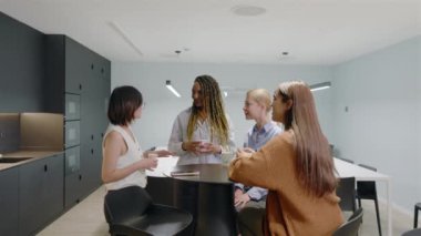 Modern bir ofiste, çeşitli maharetli profesyonellerden oluşan bir grup, takım çalışması ve yenilikçi düşüncenin fikirleri, başarıyı yönlendiren uygulanabilir planlara dönüştürdüğünü gösteriyor.