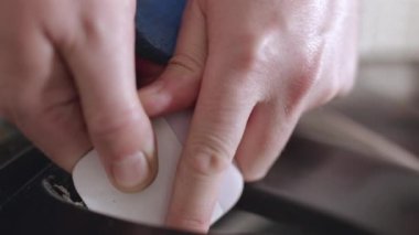 Bir yüzeyi titizlikle temizlemek ve cilalamak için bir kazıma aracını ustalıkla kullanan, etkili ve etkili temizlik teknikleri ve ev bakımı için kullanılan yöntemleri gösteren ellerin yakın plan görüntüsü