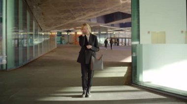 40 'lı yaşlarda deneyimli iş kadınları telefonla konuşuyor, çantasını tutuyor, her bir işe gidiş gelişi özenle ele alıyor, modern mekanlarda değerli bağlantılar kuruyor.