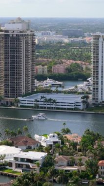 Miami Sahili 'nin canlı ve güneşli bir mahallesini görüntüleyen sinematik hava manzarası, zengin lüks evlere, yüzme havuzlarına ve manzarayı güzelleştiren yemyeşil bitkilere ev sahipliği yapıyor.