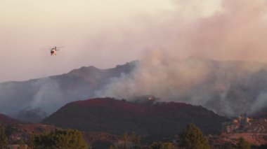 Şiddetli bir yangın Los Angeles yakınlarındaki dağlık alanları sardı. Helikopterler ve itfaiyeciler evleri korumak ve bu felaketten korunmak için alevlerle savaşıyor.