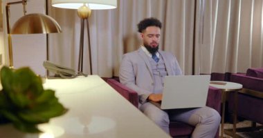 Modern bir ofis alanında, kendini işine adamış bir işadamı özenle dizüstü bilgisayarına odaklanarak, gelişmekte olan kariyerinde üretkenlik ve başarıya olan sarsılmaz bağlılığını sergiliyor.