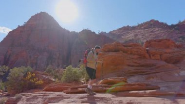 Afrikalı Amerikalı erkek, Zion Ulusal Parkı 'nın nefes kesici ve çarpıcı manzaralarında yürüyüş yapmaktan keyif alır. Bu manzara, doğanın olağanüstü güzelliğini etrafında güzel bir şekilde gösterir.