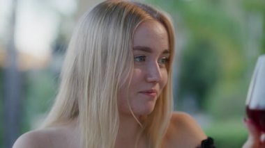 Dışarıdaki bir restoranda kırmızı şaraptan hoşlanan bir kadın. 30 'lu yaşlarda güzel, beyaz bir bayan. Arkası bulanık, doğal bir geçmişi olan lezzetli bir alkol içeceği yudumluyor. Yüksek kalite 4k görüntü