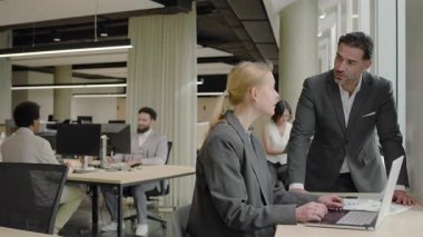 Modern bir ofis ortamında, çeşitli profesyonel gruplar iş dünyası ve işyeri dinamiklerinde takım çalışmasının, yeniliğin ve üretkenliğin önemini sergileyerek birlikte çalışırlar.