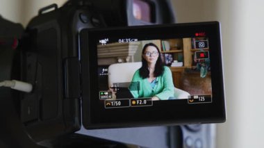 Beyaz tenli, gözlüklü esmer kadının büyüleyici iç mekanı. Kamera ekranından görüldüğü gibi şık giyinmiş bir bayanın video kaydı. Yüksek kalite 4k görüntü
