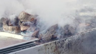 Açık havada leziz et ızgarasının detaylı görüntüsü. Kalın, bembeyaz, lezzetli organik yiyecekleri kaplayan buhar, aşçının yanında dönüyor. Yüksek kalite 4k görüntü