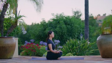 Açık hava sahnesinde meditasyon seansındaki güzel beyaz kadın. Yeşillik bahçesinin yakınındaki sabah rahatlama ayini. Yüksek kalite 4k görüntü