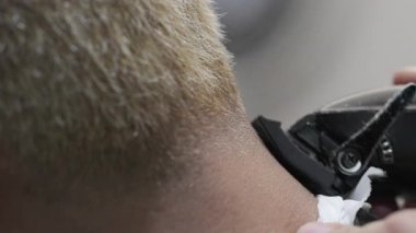 Berber dükkanında boynunu kesen tanınmamış bir adam. İşte günlük rutin bir berberin detaylı görüntüsü. Yüksek kalite 4k görüntü