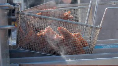 Yüksek sıcaklıkta kızartma makinesiyle detaylı bir çekim. Sağlıksız, aromalı, fast-food yemeğine yakın çekim. Yüksek kalite 4k görüntü