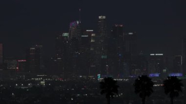 Çarpıcı sinematik gece görüntüleri Los Angeles şehir merkezinin yüksek binalarını gözler önüne seriyor. Los Angeles 'ın karanlık ve atmosferik gökyüzünün arka planına karşı nefes kesici bir şekilde aydınlatılıyor.