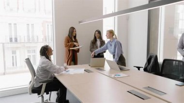 Dinamik ve modern ofis ortamı, çeşitli profesyonel gruplar yapıcı ve olumlu bir iş toplantısı için bir araya gelip birbirleriyle tokalaşırlar.