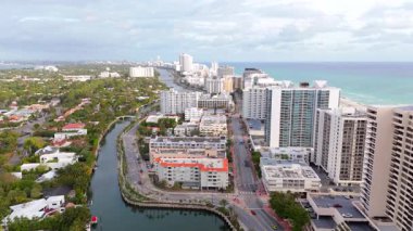 Bu çarpıcı hava manzarası, lüks evler, sudaki zarif tekneler ve parlak, güneşli bir gökyüzünün altında sallanan uzun palmiye ağaçlarının yer aldığı tropikal bir Miami Beach mahallesini gösteriyor.