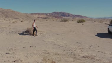 Solunum cihazındaki bir adam çorak bir çölde yürür. Umutsuzluğu, yalnızlığı ve zorlu koşullarda hayatta kalma mücadelesini yansıtan rahatsız edici bir posttapokaliptik sahne yaratır.