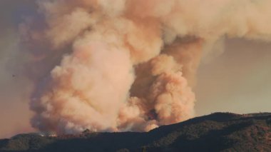 Şiddetli bir yangın Los Angeles yakınlarındaki dağları yutuyor ve yakındaki evleri tehdit ediyor. İtfaiyeciler, halkı ve halkı korumak için su damlaları için uçak ve helikopter kullanıyorlar.