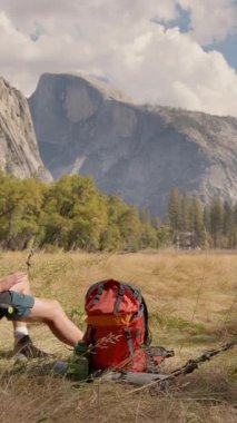 Yosemite Ulusal Parkı 'nın nefes kesen ve nefes kesici manzarasında bir adam rahatlatıcı bulur. Bu manzara doğanın inanılmaz güzelliğini ve ilham veren maceracı ruhunu güzel bir şekilde vurgular.