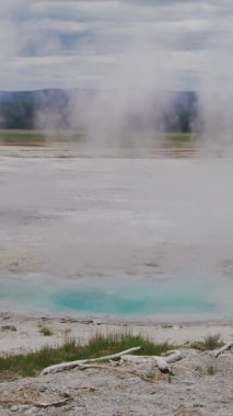 Yellowstone Ulusal Parkı 'ndaki termal alanın nefes kesici ve büyüleyici bir görüntüsü buharlı suları ve canlı renkleri sergiliyor.