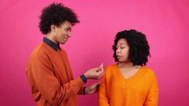 Genç bir adamın kız arkadaşına evlenme teklif ederken portresi. Şok olmuş Afro-Amerikan bir kadının yakından görüntüsü şaşırmış görünüyor. Yüksek kalite 4k görüntü