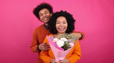 Afrika kökenli Amerikalı sevgili ve erkek arkadaşın kameraya baktığı yakın çekim. Romantik bir randevuda kucaklaşan genç bir ailenin portresi. Yüksek kalite 4k görüntü