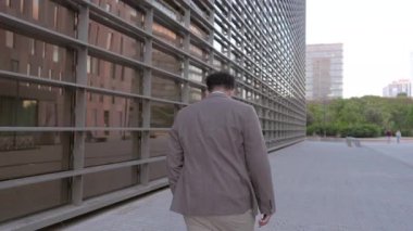 İş adamının yoğun bir şehir manzarasında geriye doğru adımlar atması, önemli bir çağrı ile meşgul olması, hızlı seyahat ve kurumsal kültürün yaşamını sergilemesi, her anın önemi ve bağlantıları hayati önem taşıyor.